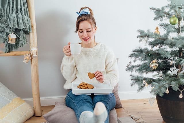 Ni dieta ni culpa: equilibrio y movimiento para disfrutar sin límites en Navidad | UFV happy-young-woman-in-cosy-sweater-drinking-hot-tea-2026-01-08-05-39-11-utc Ni dieta ni culpa: equilibrio y movimiento para disfrutar sin límites en Navidad | UFV Estudiar en Universidad Privada Madrid